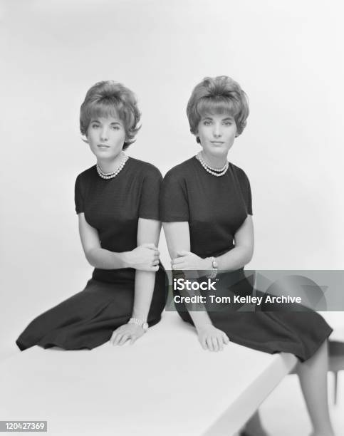 Twin Sisters Sentado Frente A Fondo Blanco Retrato Foto de stock y más banco de imágenes de De Archivo
