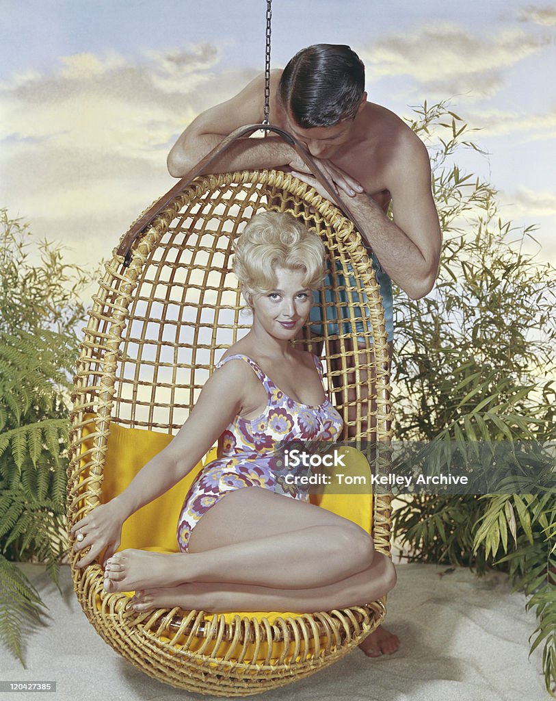 Man leaning on swing стулом и любоваться женщина, улыбающаяся - Стоковые фото Архивный роялти-фри