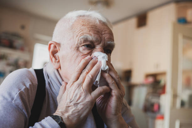 istock Senior man have allergy and blowing nose with tissue 1204274295