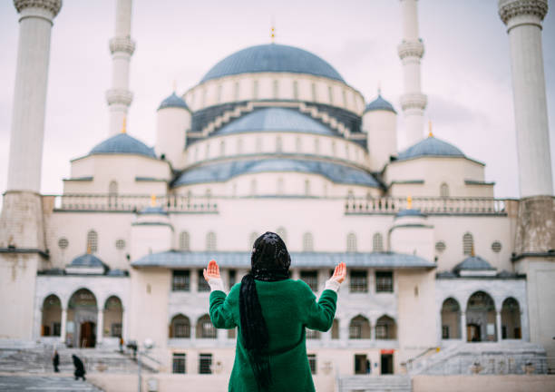 Muslim Woman Praying in Front of Mosque