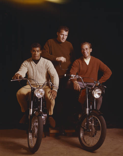 homens com motocicletas contra fundo preto, sorriso, retrato - 1966 - fotografias e filmes do acervo