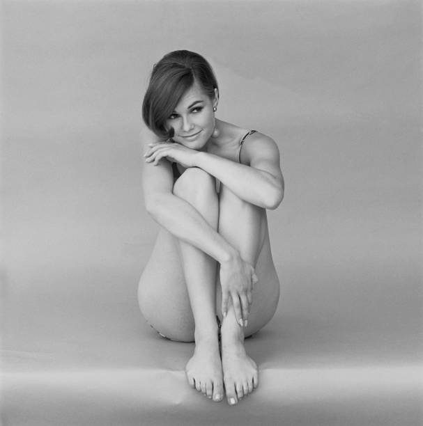 mujer joven en traje de baño, sonriendo - abrazar las rodillas fotografías e imágenes de stock