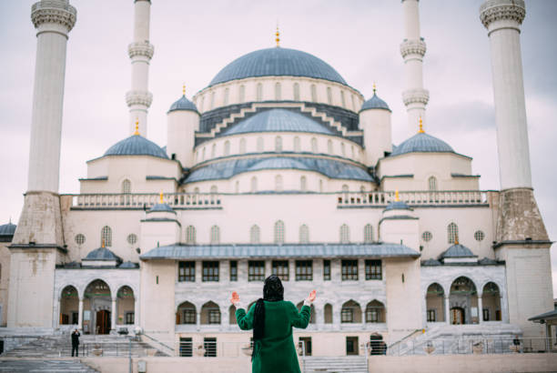 Muslim Woman Praying in Front of Mosque