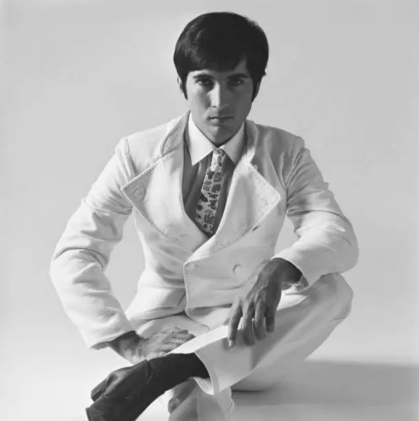 Photo of Young man sitting on white background, portrait