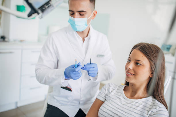 istock Young woman receiving dental checkup 1204276418