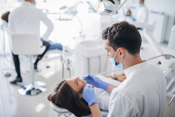 istock Young woman receiving dental checkup 1204276468