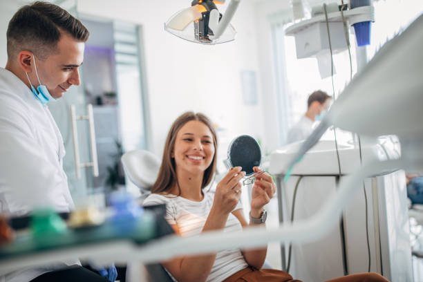 istock Young woman receiving dental checkup 1204276546