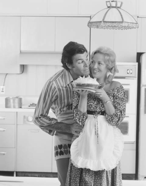 Couple with meringue in kitchen, smiling  1974 stock pictures, royalty-free photos & images