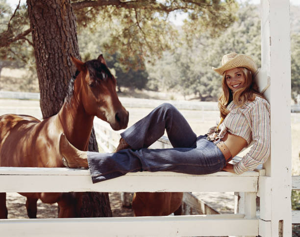 Young cowgirl sitting on fence with horses, smiling, portrait  1974 photos stock pictures, royalty-free photos & images