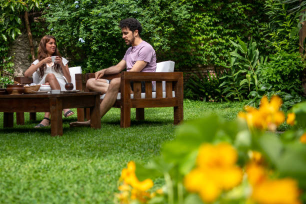 istock Young man and woman sitting in back yard and talking 1204280268