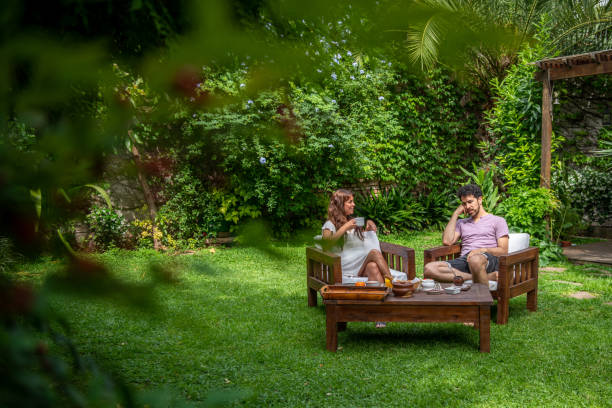 istock Young couple sitting in the back yard and talking 1204280273