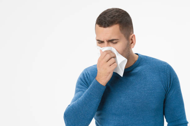 istock Handsome man feeling unwell and coughing as symptom for cold over white isolated background 1204282990