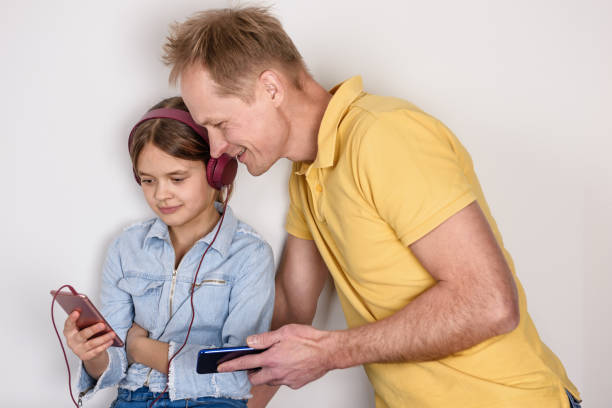 istock Father and doughter looking into smartphone. 1204283446