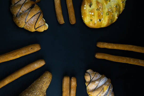 Different types of fresh bread with grain on a black rustic background. the bread stands around