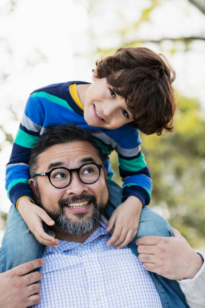 istock Hispanic man carrying his little boy on shoulder 1204284538