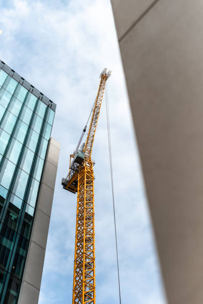 istock Construction site with tall cranes on background of modern office buildings city centre blue sky clouds 1204284579