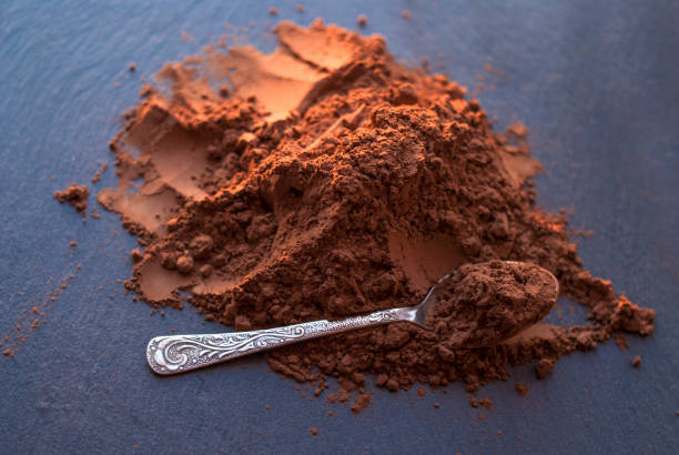 istock cocoa powder in a spoon, scattered on a dark board, 1204284626