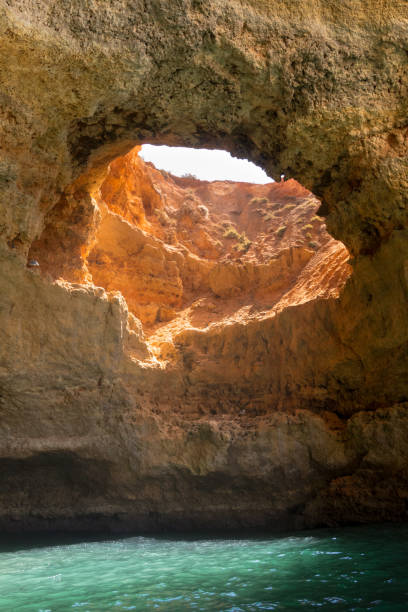 istock Cave in the water with natural hole in the ceiling through which natural light falling down to the water in Algarve region in Portugal 1204284771