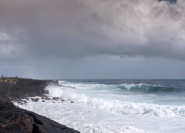 istock Azure wave crashes on black lava on Kaimu Beach, Hawaii, USA. 1204285787