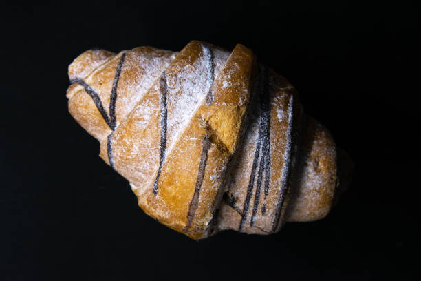istock Croissant with chocolate isolated on a black background 1204285934