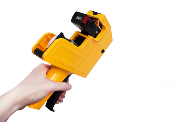 istock Yellow etiquette gun for price tags on a white background. Isolate 1204285989