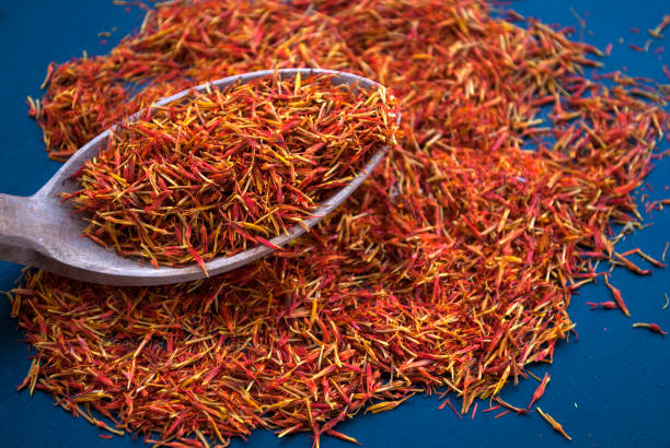 istock Saffron in a wooden spoon on a dark table close-up 1204286876