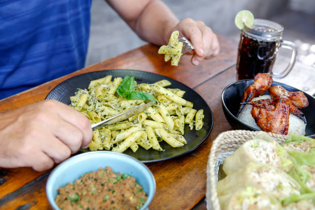 A fork holding an array of delicious penne pasta, showcasing an appetizing meal