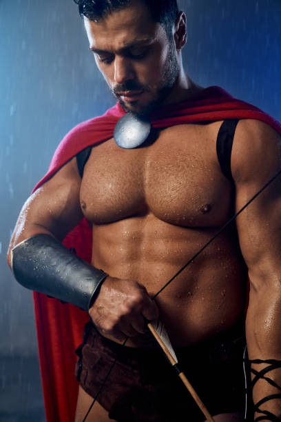 istock Muscular wet spartan holding bow with arrow. 1204288490
