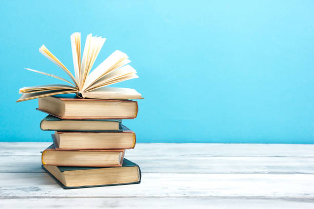 istock Open book, hardback books on wooden table. Back to school. Copy space. 1204290574