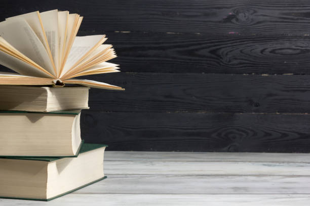 istock Open book, hardback books on wooden table. Back to school. Copy space. 1204290695