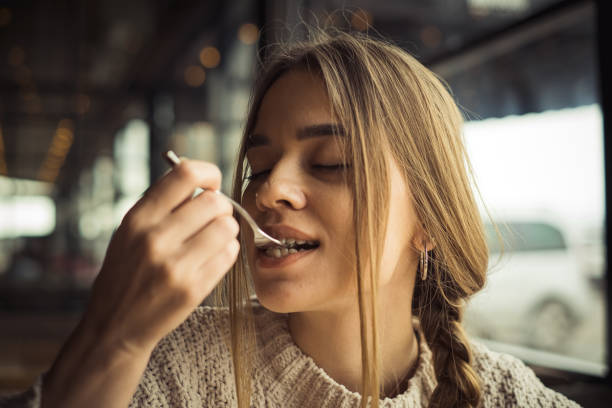 istock young woman eating dessert 1204293026