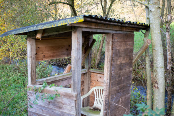 istock Old hunting hut with plastic chair and moss 1204293074
