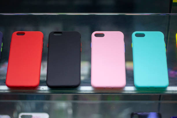istock 3 different color phone cases in the shop window.. There is a glass in front. 1204294367