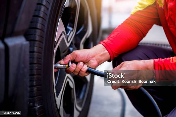 Driver Checking Air Pressure And Filling Air In The Tires Close Up Safety Before Trave Stock Photo - Download Image Now