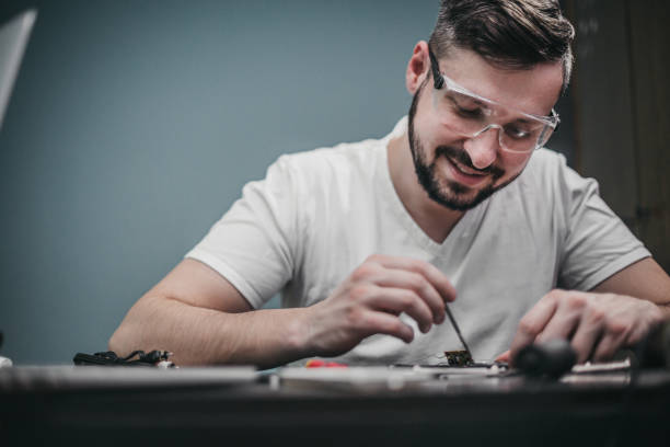 istock Repairman disassemble motherboard with screwdriver 1204294593