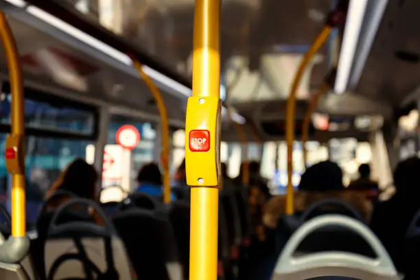 Yellow post with red STOP button inside a London Double-decker bus