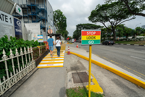 Singapore. January 2020. A warning sign to pedestrians for the exit of vehicles from a construction site
