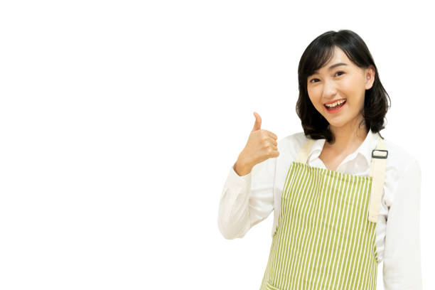 bliska młoda japońska dorosła kobieta w zawodzie szefa kuchni nosi uniform i podnosi kciuk do góry, aby uzyskać najlepszy wynik odizolowany na białym tle dla koncepcji dobrego smaku - restaurant sign sign language food zdjęcia i obrazy z banku zdjęć