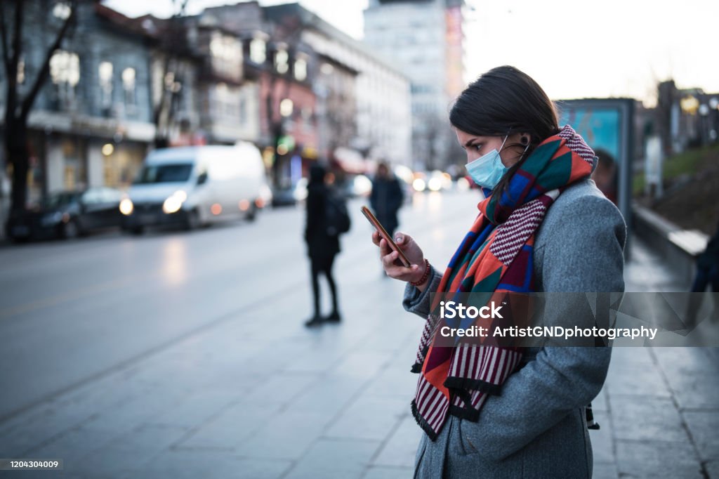 Mujer con máscara usando el teléfono en la calle. - Foto de stock de Asistencia sanitaria y medicina libre de derechos