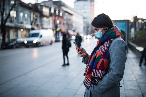Woman With Mask Using Phone On The Street.