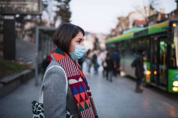 frau in der stadt trägt schutzbeschützende gesichtsmaske. - air pollution fotos stock-fotos und bilder