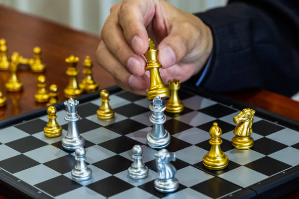 istock Chess game on chess board behind business man background. Business concept to present financial information and marketing strategy analysis. Investment target in global economy and digital commercial. 1204307428