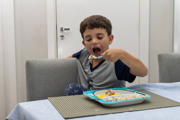 입을 벌리고 손에 숟가락을 들고 삼킬 준비를 한 어린이. - eating cereal student human mouth 뉴스 사진 이미지