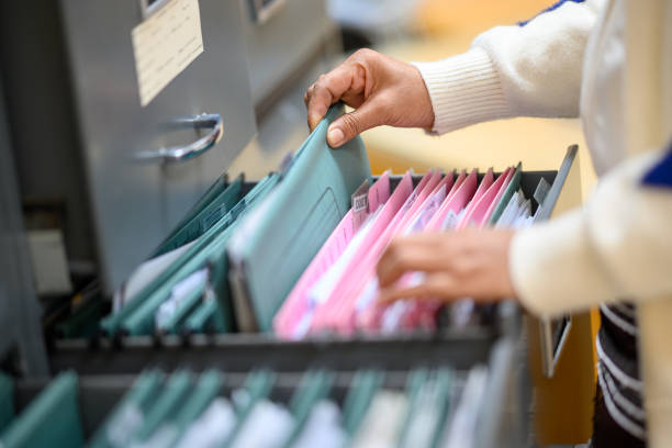 istock Working women searching for documents in filing cabinets at the office 1204318230
