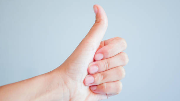istock fingers on a gray background. hand with thumb up on gray background 1204318328