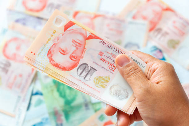 istock Hand holding Singapore Dollar banknote,Background 1204326232