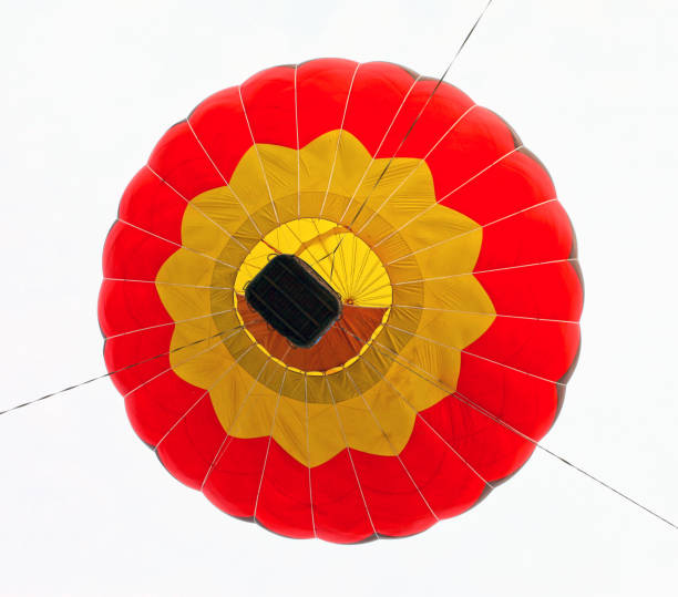 Hot air balloon drifting over field of oilseed rape in the Harwardian Hills in North Yorkshire in the northeast of England.