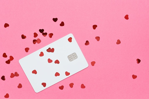 Credit card and hearts on a pink background