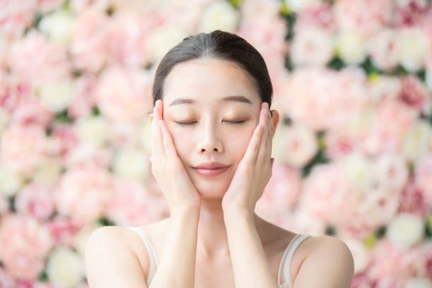 japanese woman beauty image pale pink flower background skin cheek stock pictures, royalty-free photos & images