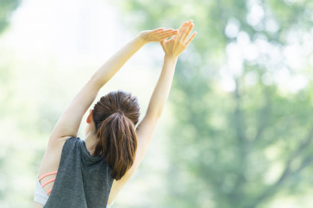 yoga poses at the park - relaxation exercise stretching exercising women imagens e fotografias de stock